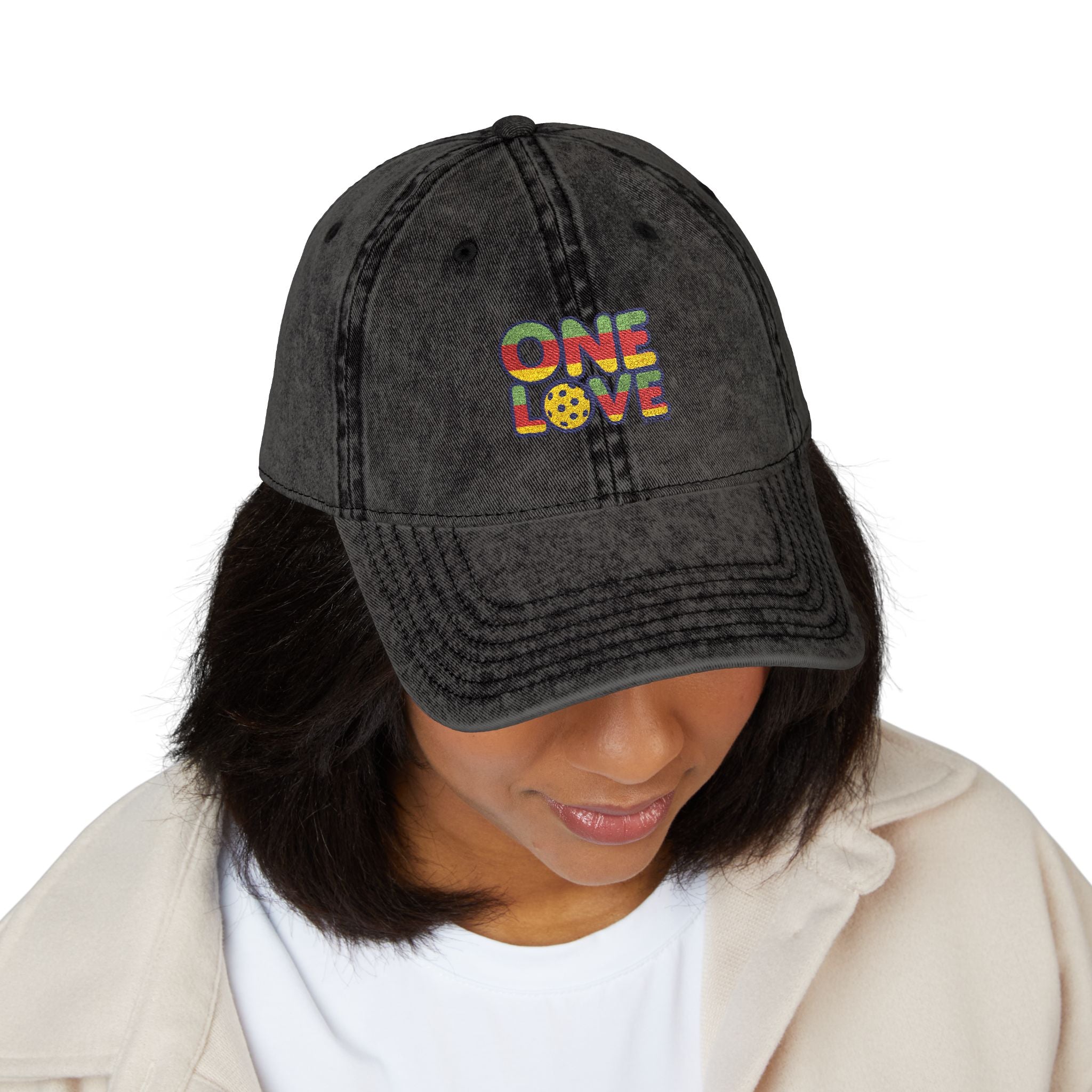 Person wearing a black cap with 'ONE LOVE' text in colorful letters on a white background